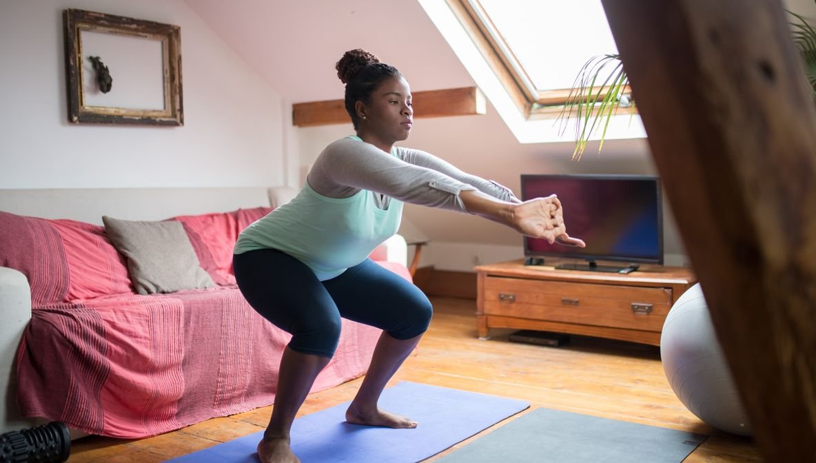 Frau macht Cardio-Übungen zu Hause ohne Geräte